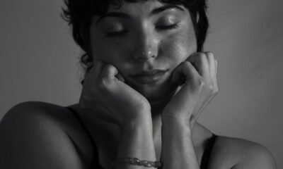 Moody black and white portrait of a woman with eyes closed, conveying deep emotion.