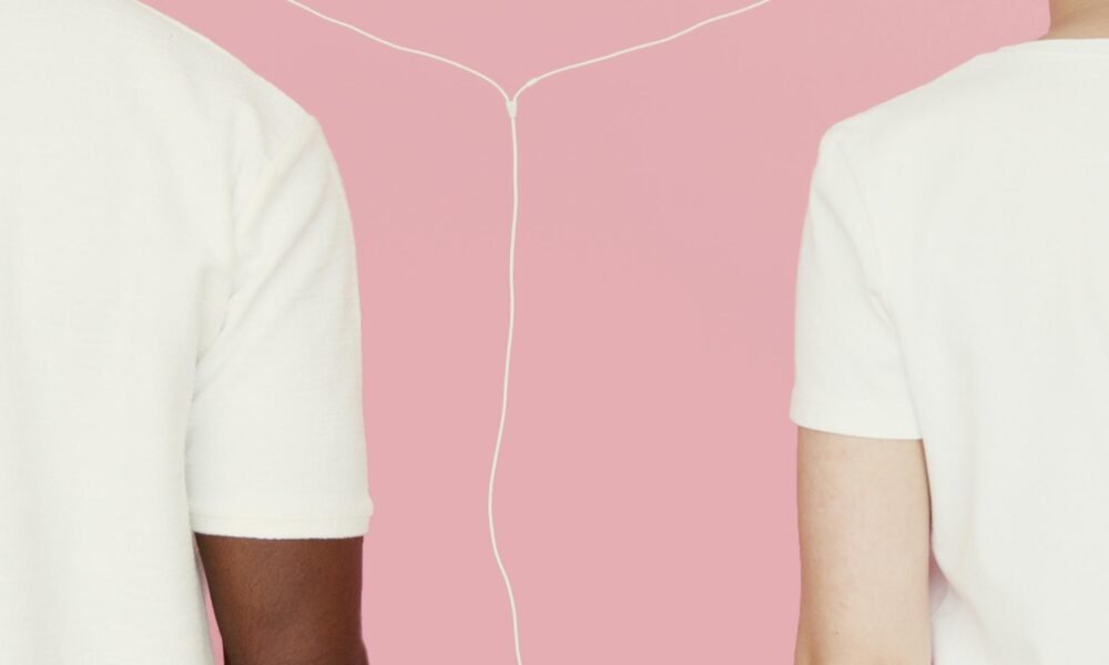 Two people connected by earphones against a pink background.